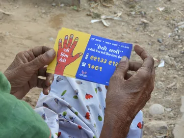 Someone holding a phamplet about prevention of violence against women and girls.