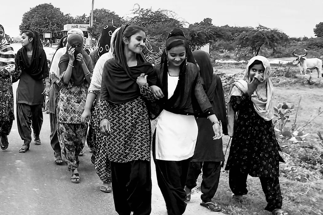 adolescent girls walking hand in hand and smiling